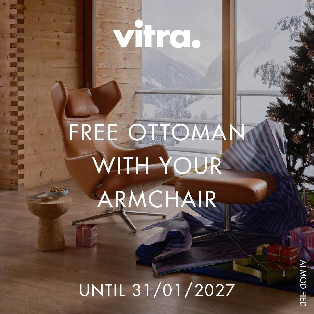 Brown leather armchair with matching ottoman set in a cozy wooden room by a large window overlooking a snowy mountain scene, with a small wooden side table and wrapped gifts nearby.